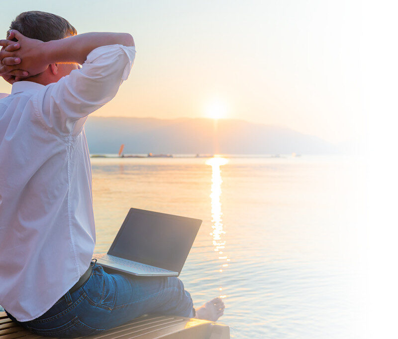 Recreational entrepreneur. Man with laptop in the morning on the beach working