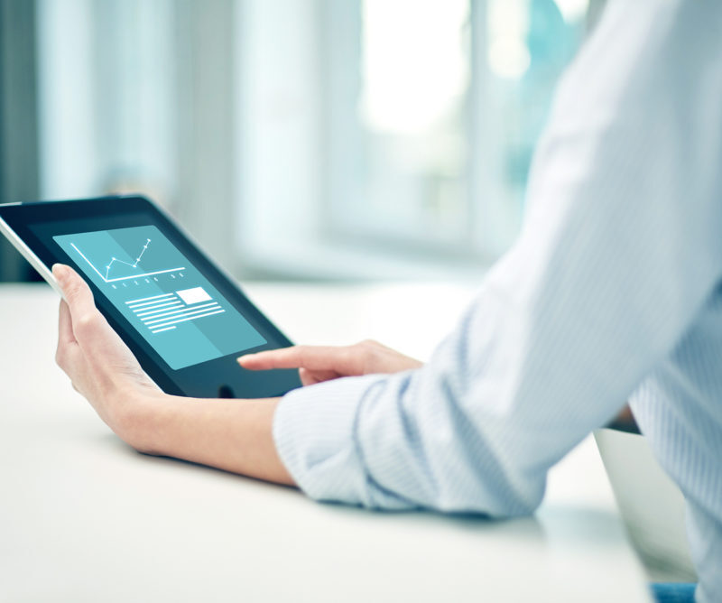 business, technology, statistics, progress and people concept - close up of woman with tablet pc computer showing growing charts at office or home