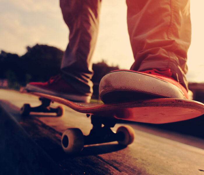 closeup of skateboarder legs skateboarding at sunrise skatepark